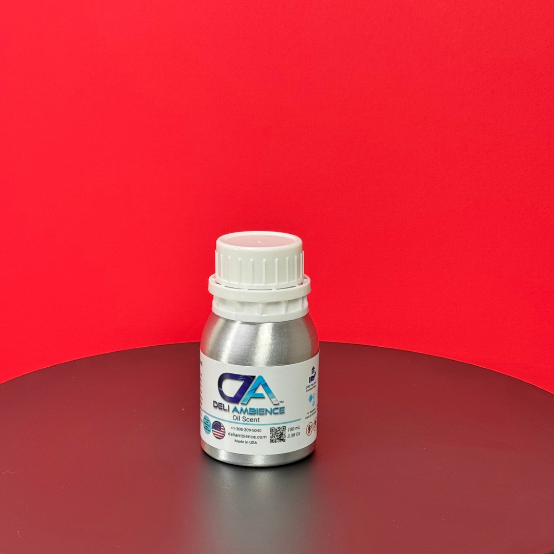 A silver bottle labeled "Deli Ambience 'DA Cozy Home' Oil Scent 100 ML" sits on a black surface with a red background, exuding the inviting aroma of Cozy Home oil fragrance.