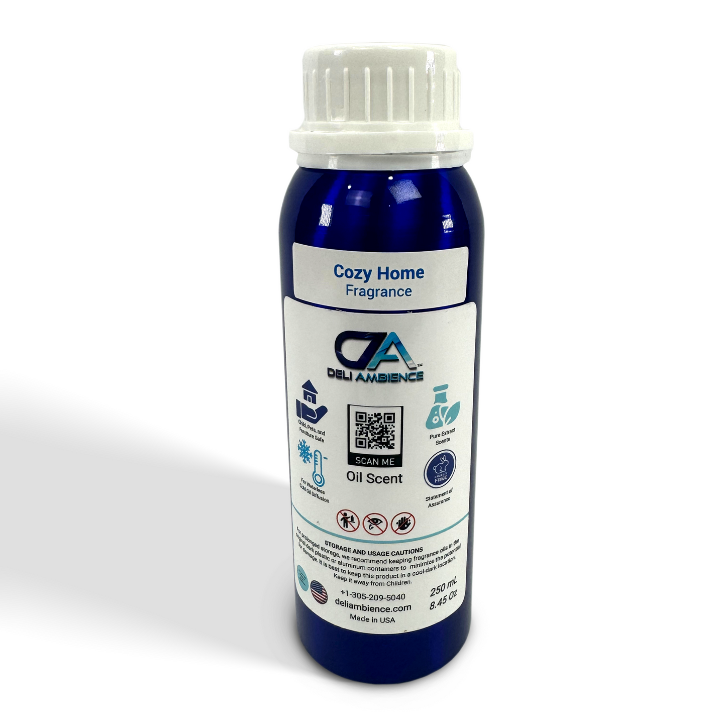 A blue cylindrical bottle with a white cap labeled "Deli ambience 'DA Cozy Home' Oil Scent 250 ML" from Deli Ambience. The comforting aroma is perfect for creating a cozy home atmosphere. The label includes usage instructions, contact information, and a QR code.