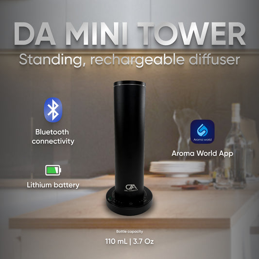 A sleek black DA Mini Tower Scent Diffuser stands on the kitchen counter, seamlessly blending technology with aromatherapy. Featuring Bluetooth connectivity and a lithium battery, it syncs effortlessly with the Aroma World app. Its 110mL capacity is perfect for infusing essential oils into your space.