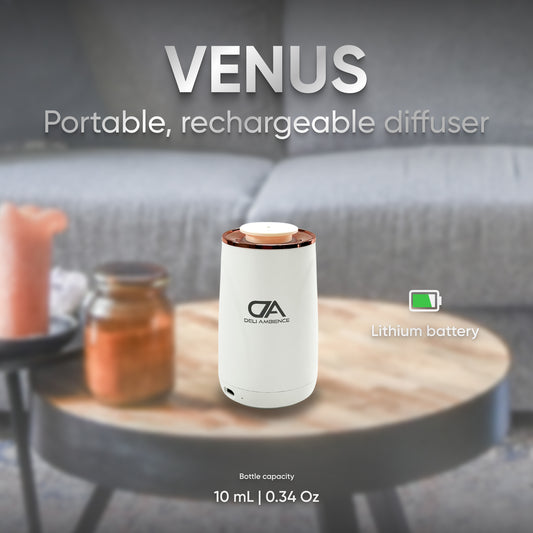A Venus Compact Oil Diffuser USB-C Power, ideal for small spaces, sits on a table with a lithium battery and 10 mL capacity, against a blurred background.