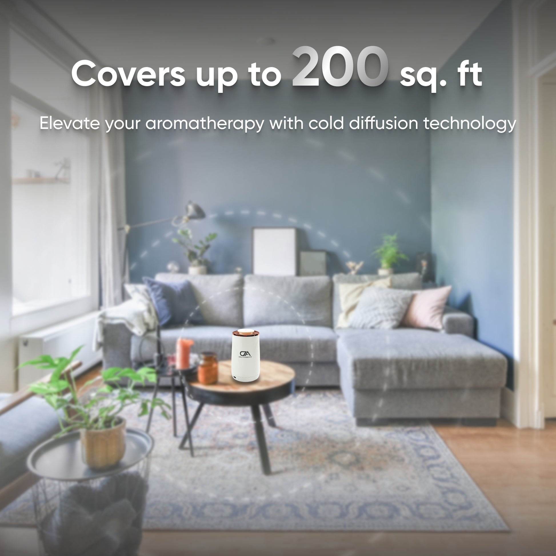 Living room with a gray sofa, coffee table, plants, and the Venus Compact Oil Diffuser USB-C Power. Text reads: "Covers up to 200 sq. ft. Elevate your aromatherapy in small spaces with cold diffusion technology.