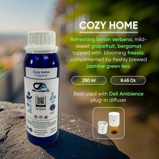 A bottle labeled "Deli ambience 'DA Cozy Home' Oil Scent 250 ML" features a comforting aroma with key notes of lemon verbena, grapefruit, bergamot, and freesia, complemented by jasmine green tea. Recommended for use with a Deli Ambience plug-in diffuser.