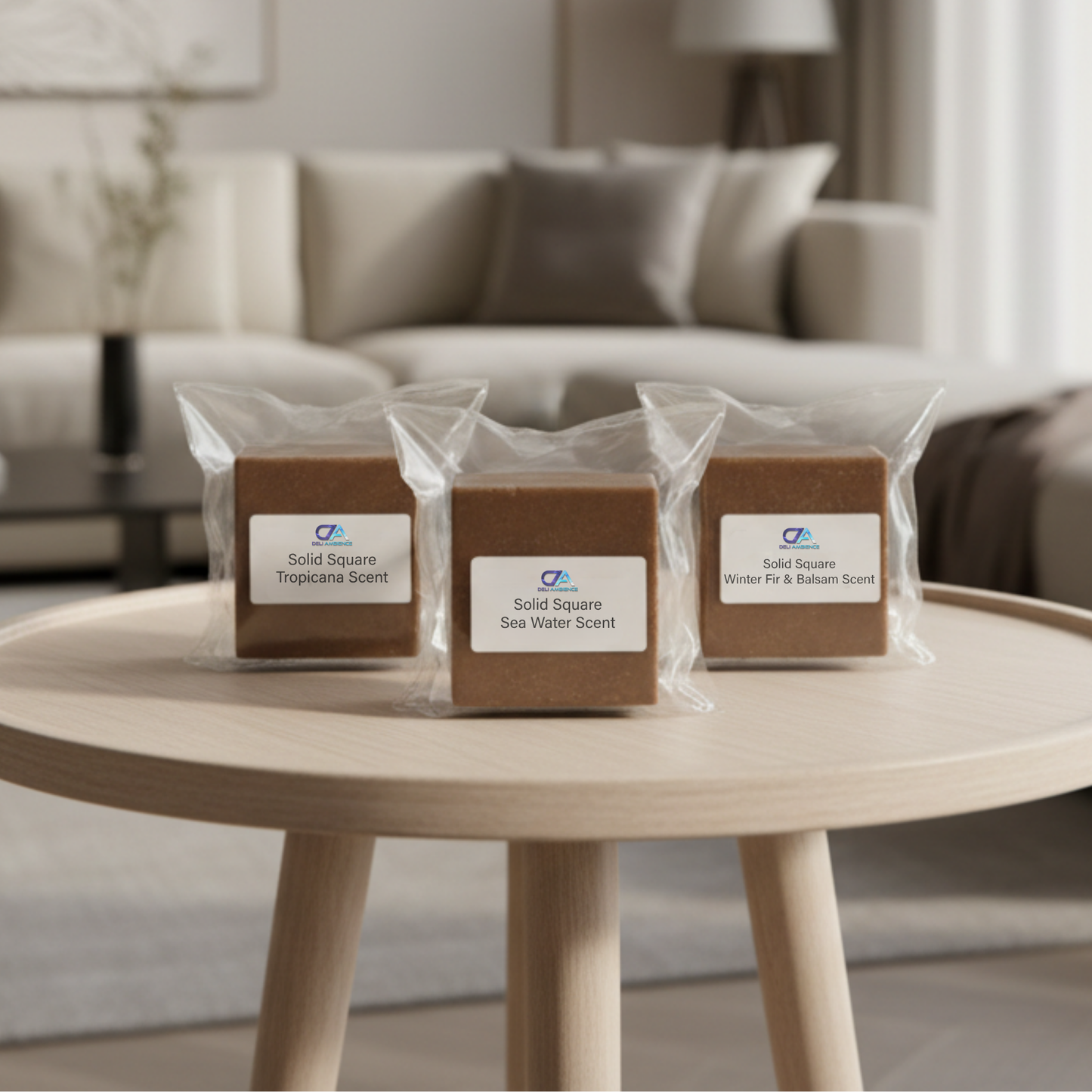 Three individually wrapped Solid Square Scents brown soap bars, each labeled with a different fragrance, sit on a round wooden table in a modern living room.