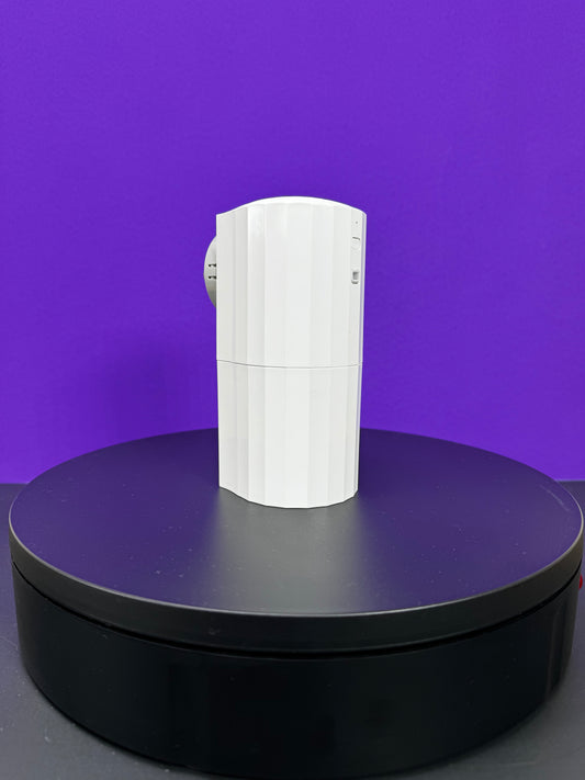 A white coffee cup on top of a purple background, with a DA Plug In Scent Diffuser nearby.