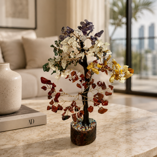 The Chakra Tree, a decorative sculpture with multicolored crystal stone leaves, sits on a marble table in a modern living room, bringing an elegant touch of Feng Shui to the space.